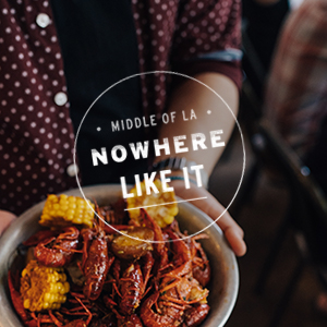 Holding bowl of boiled crawfish and corn-on-the-cob